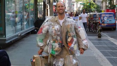 صورة رجل القمامة من أجل البيئة يرتدي 100 رطل من قمامته