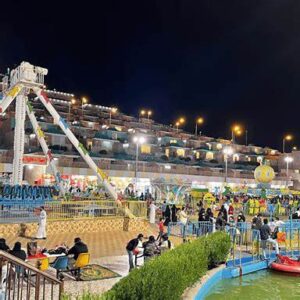 مشهد عام لألعاب الملاهي في منتزه الجبل الأخضر، يظهر أرجاء المنتزه أثناء التشغيل والذين توفر خلفية